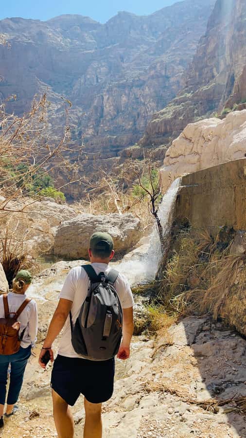 Muscat: Wadi Shab, Romantic Cave and Sinkhole Full-day Trip - Crossing the river into Wadi Shab